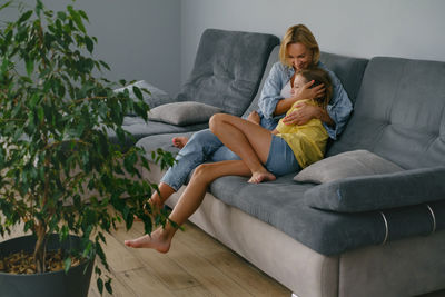 Portrait of young man sitting on sofa at home