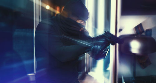 Portrait of burglar holding gun