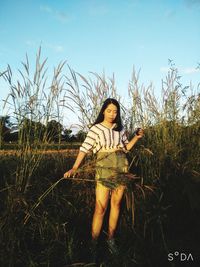 Woman standing on field against sky