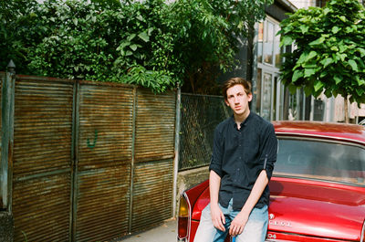 Portrait of young man standing against plants