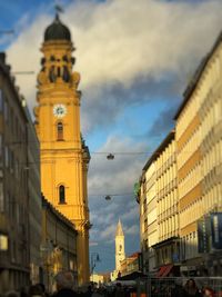 Low angle view of clock tower against cloudy sky