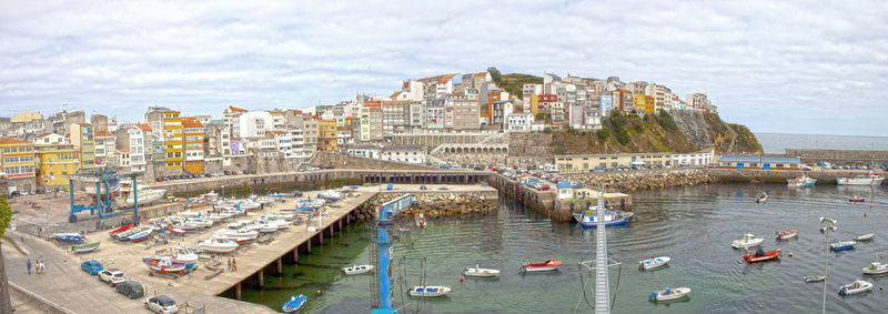 High angle view of boats in sea against buildings in city