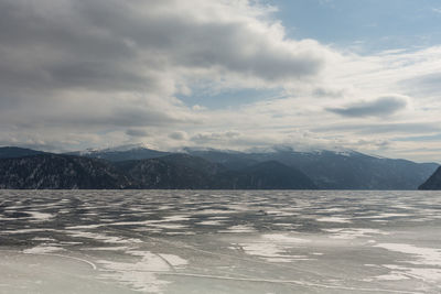 View of beautiful drawings on ice from cracks on the surface of lake teletskoye in winter, russia