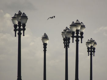 Low angle view of seagulls perching on street light