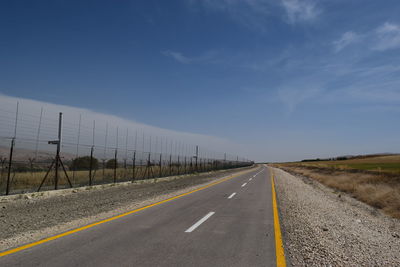 Empty road along countryside landscape