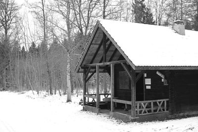 Built structure on snow covered field in forest
