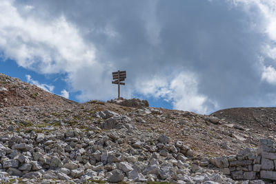 View of sign on rock against sky