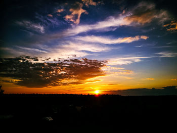 Scenic view of silhouette landscape against dramatic sky during sunset