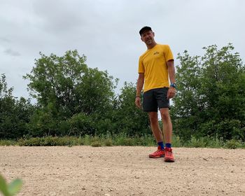 Full length of man standing by tree against sky