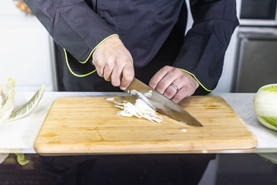 Midsection of person preparing food on table in restaurant