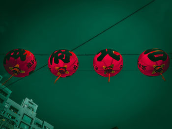 Low angle view of illuminated lanterns hanging against sky