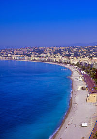 Scenic view of sea and buildings against blue sky