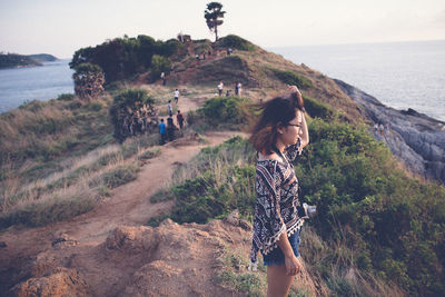 Side view of woman standing on mountain during sunset