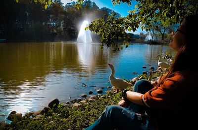 Woman sitting by lake