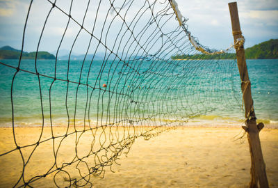 Scenic view of sea seen through fence