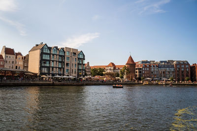 River by buildings against sky in city