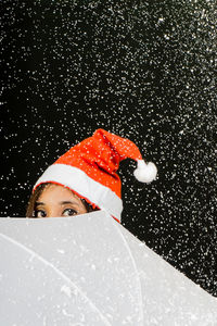 Close-up portrait of young woman over black background