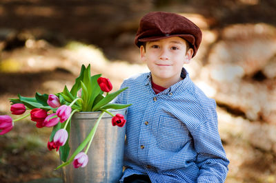 Portrait of boy with red flowers