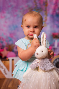 Close-up of cute girl biting plush rabbit