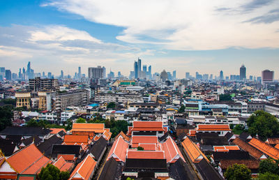 High angle view of city buildings against cloudy sky