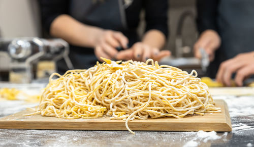 Raw homemade pasta on wooden cutting board. uncooked fresh pasta