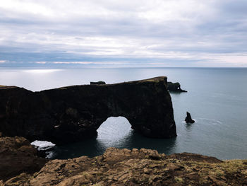 Rock formations by sea against sky