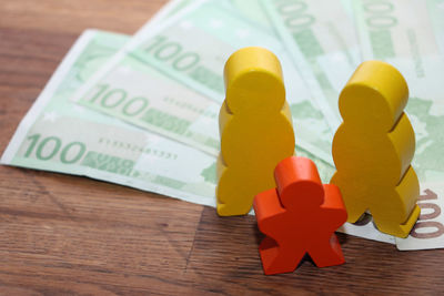 Close-up of toy on paper currencies on table