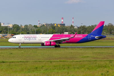 Airplane on airport runway against sky