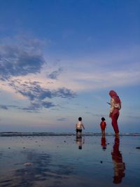 People on beach against sky