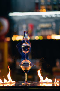 Close-up of lit candles on glass