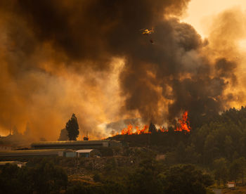 Firefighter helicopter fighting against a forest fire during day in braga, portugal.