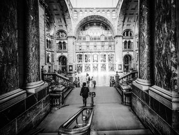 Rear view of people walking in historic building