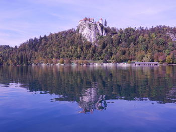 Scenic view of lake by trees against sky