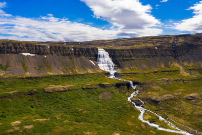 Scenic view of waterfall against sky