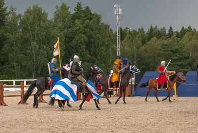 Group of people riding horses on trees