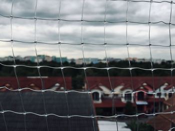 Buildings and sky seen through net