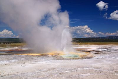 Steam emitting from hot spring against sky