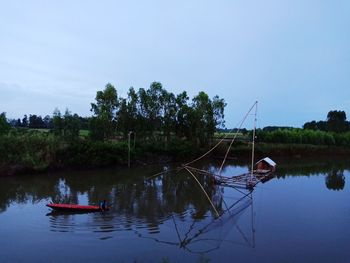 Boat moored in lake against sky