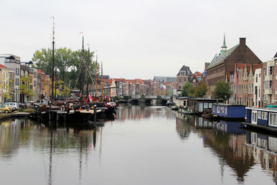 Boats moored in river against buildings in city