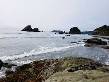 Rocks on beach against sky