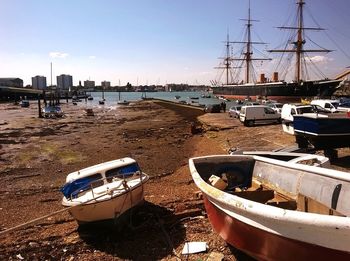 Boats moored at harbor against sky