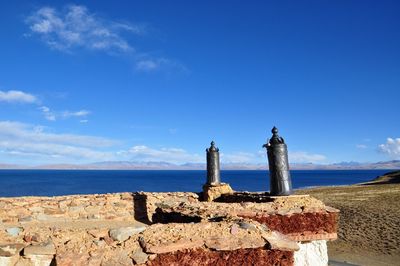 Built structure by sea against blue sky