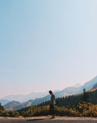 Man standing on mountain against clear sky