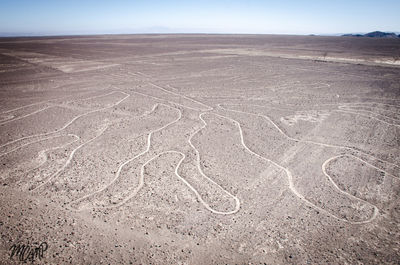 Tire tracks on desert against sky