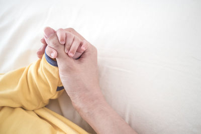 Low section of person resting on bed