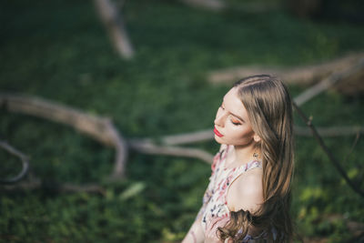 High angle view of beautiful young woman sitting in park