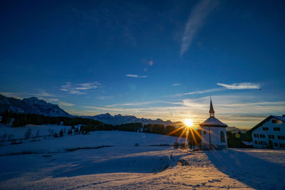 Scenic view of snowcapped mountains against sky during sunset