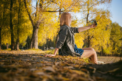 Woman standing by tree in forest