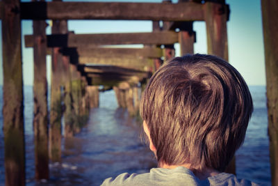 Rear view of boy looking at pier