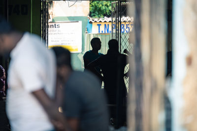 Rear view of people standing in city